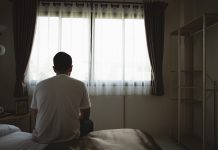 Silhouette depressed man sadly sitting on the bed in the bedroom. Sad asian men suffering depression insomnia awake and sit alone on the bed in bedroom. Depression health people concept.