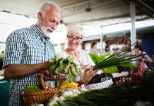 Mature couple shopping vegetables and fruits on the market. Healthy diet.