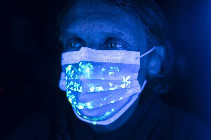 Man wearing protective face mask with uv light