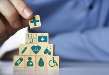 Medical health insurance concept. Men's hand arranging wood blocks with healthcare medicine icons
