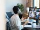 Man in Headphones Participating in a Virtual Group Meeting