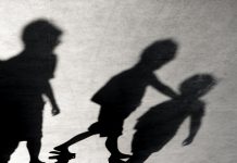 Blurry shadows of three boys friends walking together