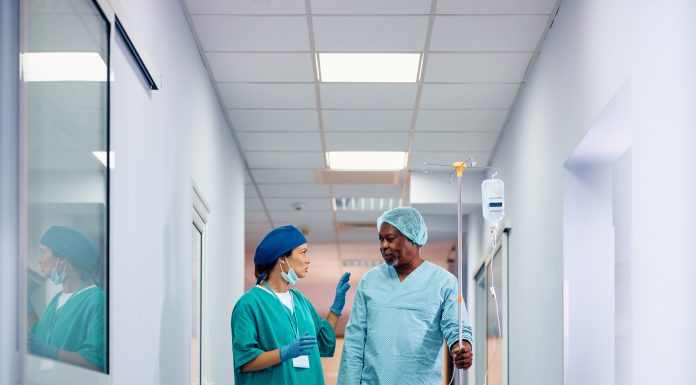 Female doctor communicating with African American senior man who is recovering after surgery in the hospital. NHS case studies