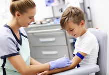 Brave little boy having blood collection for tests