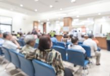 Blur medical background clinic service counter lobby with patient paying bill at cashier desk in hospital