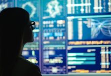 The businesswoman in glasses standing near the display