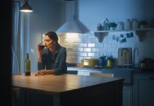 Portrait of Beautiful Lonely Young Woman Drinking from a Wine Glass in the Dark Kitchen. Depressed and Sad Adult Girl with Alcohol Problem Drinks Alone, Bad Relationships, Work Stress, Other Problems