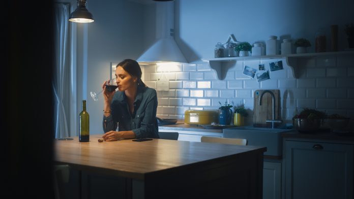 Portrait of Beautiful Lonely Young Woman Drinking from a Wine Glass in the Dark Kitchen. Depressed and Sad Adult Girl with Alcohol Problem Drinks Alone, Bad Relationships, Work Stress, Other Problems