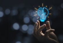 Hand holding drawing virtual lightbulb with brain on bokeh background for creative and smart thinking idea concep