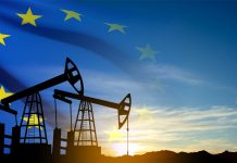 Oil rigs silhouette against sunset ana European union flag