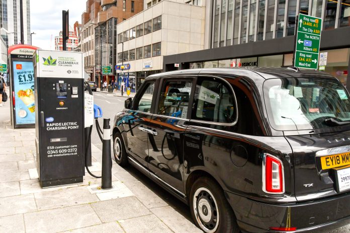 Electric London black cab connected to a rapid charging point in central London