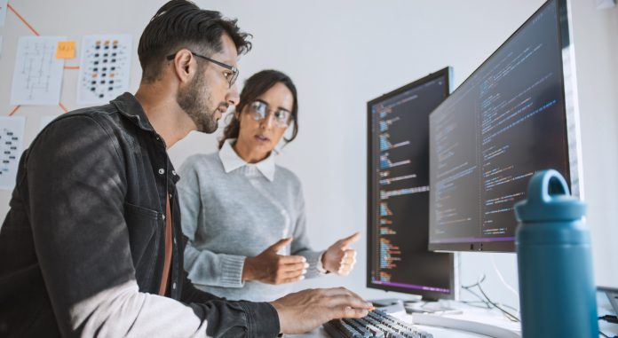 Hispanic Latin American couple, software engineer developer use computer, work on program coding together at home office. Programming language development technology, freelance job concept