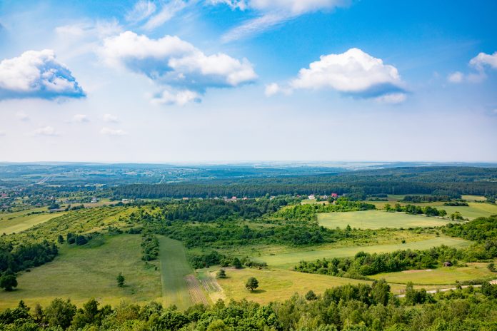 Experience a Breathtaking Panoramic View of a Lush Green Landscape with Beautiful Blue Skies