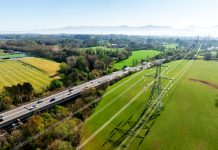 Electricity pylon towering over green fields in north wales
