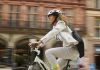 woman cycling through the city centre