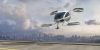 A generic white electric powered Vertical Take Off and Landing eVTOL aircraft with four rotors, coming in to land on roof top helipad with high city city buildings in the background. The sky is bright with clouds and it's late afternoon / early morning.