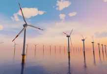 3D Rendering of Giant wind turbines farm located in the open sea, sunset shot. Concept of renewal energy using windmills