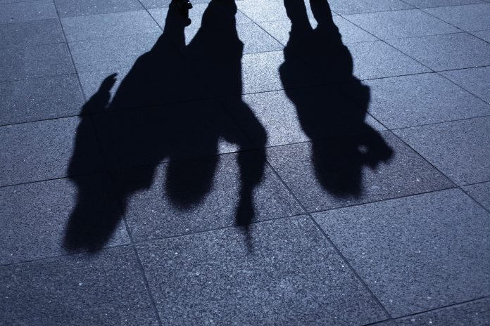 People threatening in blue night shadows