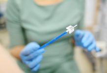 Gynecologist examines a patient takes a smear from a woman cervix. Close up view of doctor hands with gynecological cytobrush. Diagnosis of female viral and infection diseases. Reproductive health.