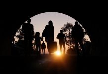 Refugees and immigrants looking for a new hope in life. Silhouette. Column of migrants passing through a tunnel. Abandon your lands for a better future. 3d rendering