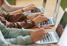 Teenage girls using typing on laptops