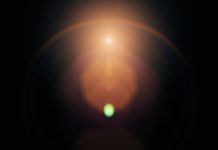 Lens flare on black background. Overlay design element