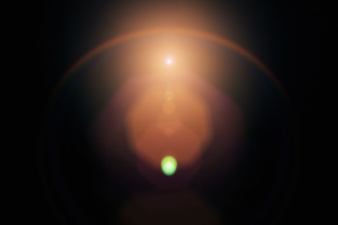 Lens flare on black background. Overlay design element
