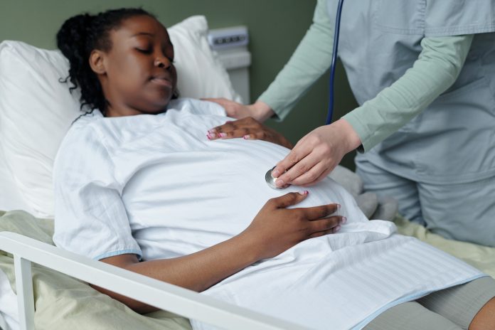 Caring Nurse Attending African American Pregnant Woman