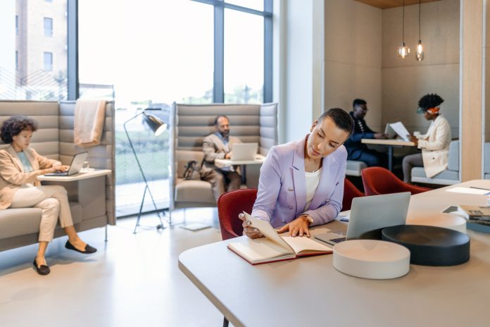 Stylish young short haircut businesswoman working in an open plan office