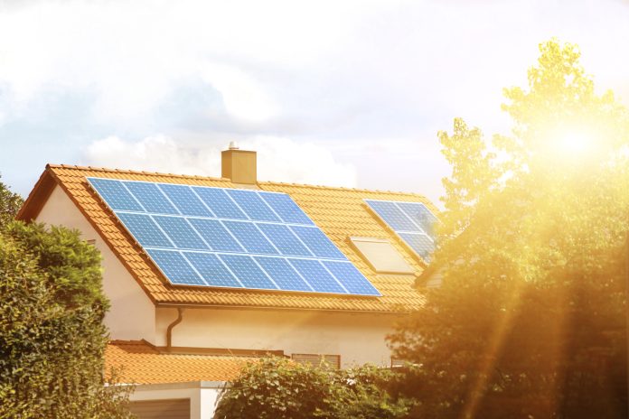 Solar panels on the tiled roof of the building in the sun. Electricity production for own needs and for sale
