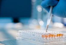 Lab technician injecting liquid into a microtiter plate