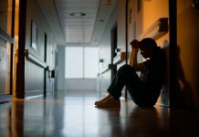 Doctor, stress and woman with depression, burnout and tired in hospital for medical news. Nurse, anxiety and female person with mental health, headache and sad sitting on floor for patient death