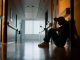 Doctor, stress and woman with depression, burnout and tired in hospital for medical news. Nurse, anxiety and female person with mental health, headache and sad sitting on floor for patient death