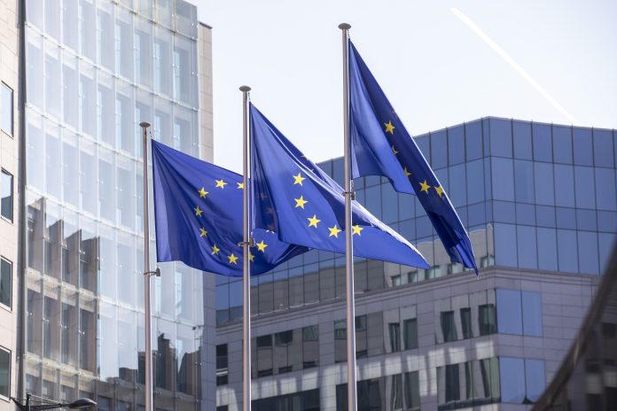 EU flags outside a modern office building in Brussels