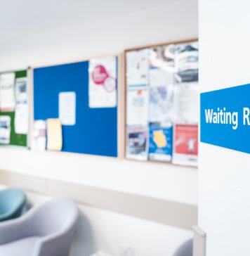 Shallow focus of a typical NHS hospital waiting room sign seen in a British hospital.