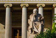 Marble statue of the Greek philosopher Socrates on the background of classical columns