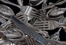 A photograph of sterling silver flatware for eight in a jumble