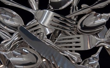 A photograph of sterling silver flatware for eight in a jumble