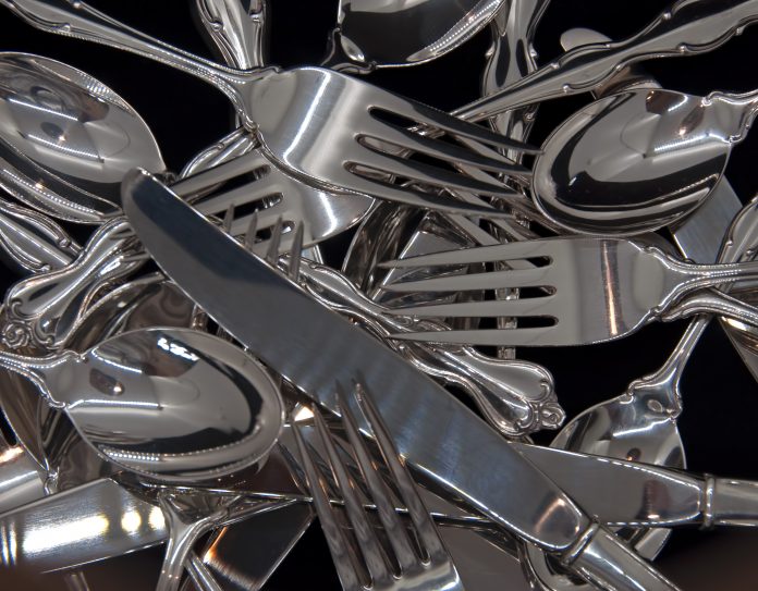 A photograph of sterling silver flatware for eight in a jumble