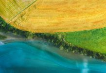 Aerial view above rural fields and Rauma river landscape in Norway top down scenery Romsdalen valley agriculture countryside