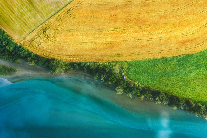 Aerial view above rural fields and Rauma river landscape in Norway top down scenery Romsdalen valley agriculture countryside