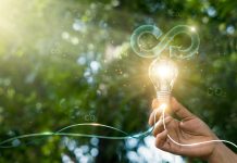 Circular economy. Hand hold light bulb with circular icon. Energy consumption and CO2 emissions, reusing and recycling existing materials for future growth of business and environment sustainable.