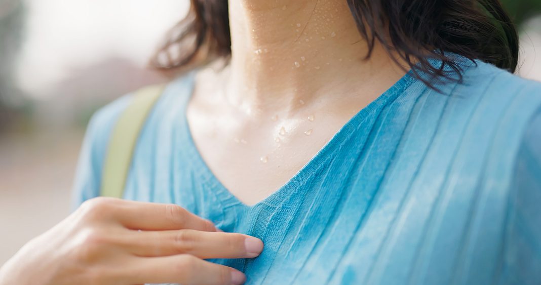 Closeup side view asian young woman is feeling so hot - she got sweaty and wet clothes uncomfortable