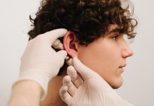 Process of examination patient before otoplasty surgery. Surgeon doctor makes palpation before cosmetic ear surgery.