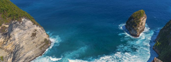 Banner Turquoise ocean sea water white wave pattern splashing deep blue sea. Banner Tropical sea beach Seascape dark background wave splash on rock. Summer Ocean Surface big wave with copy space