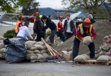 KELOWNA, CANADA - MAY 12: An emergency response worker piles sandbags on a pallette on May 12, 2017 in Kelowna, British Columbia, Canada.