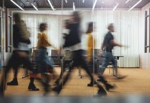 Businesspeople walking at modern office. Group of business employees at coworking center. Motion blur. Concept work process. Wide image