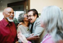 friends greeting each other at door with social kiss on cheek