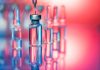 Close up shot of vaccines - glass bottles, ampules and syringe with needle. Good for illustration of flu shot, vaccination and covid-19