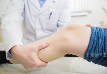 closeup doctor the traumatologist examines the patient the patient's ankle leg